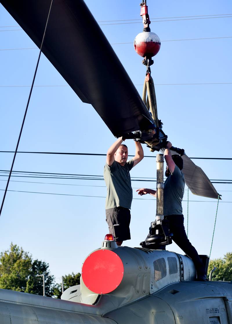 Crews from Midwest Aerospace and Dave's Crane & Wrecker Service help lift the main rotor blade to a Huey helicopter on Sept. 30 in Baxter.