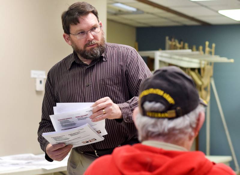 Jasper County Engineer Michael Frietsch hands out documents explaining the secondary roads department's new approach to gravel roads during a public meeting April 25 in Lynnville City Hall.