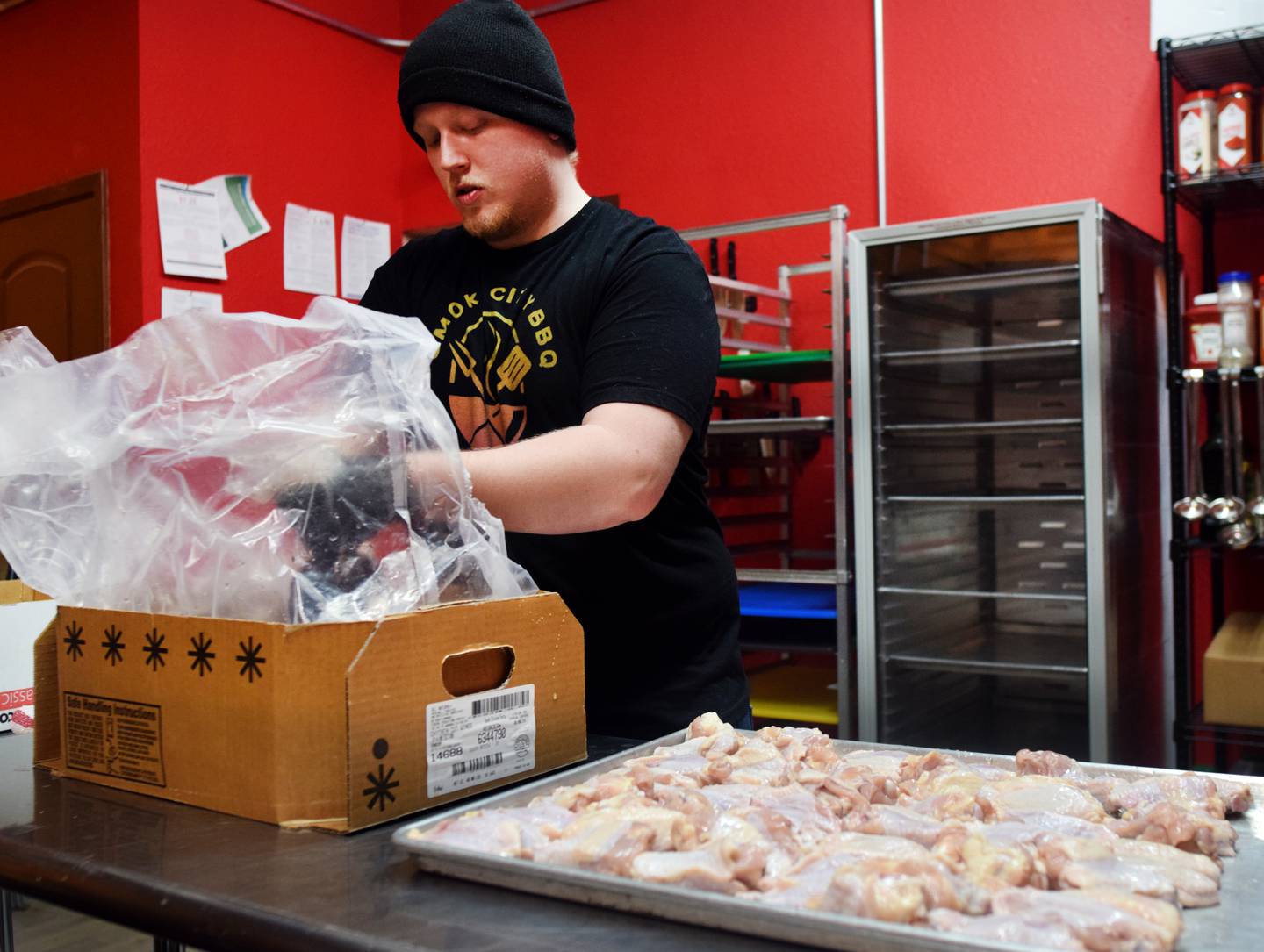 Ryan Cass, a cook for Smoke City BBQ, prepares a batch of smoked wings. The Newton BBQ restaurant opened in January inside The Thunderdome.