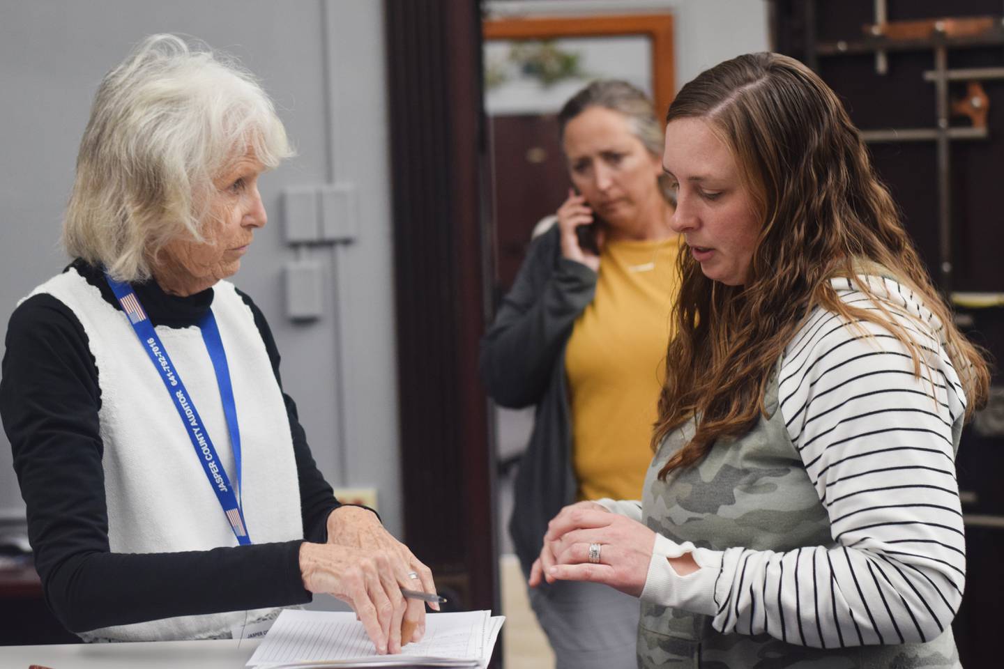 Jasper County Auditor Jenna Jennings, right, speaks with a volunteer during Election Day.