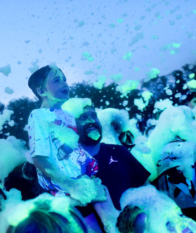 Kids participate in Driving Cap Entertainment's UV Glow Foam Party during Newton Fest on June 9 in Maytag Park in Newton.