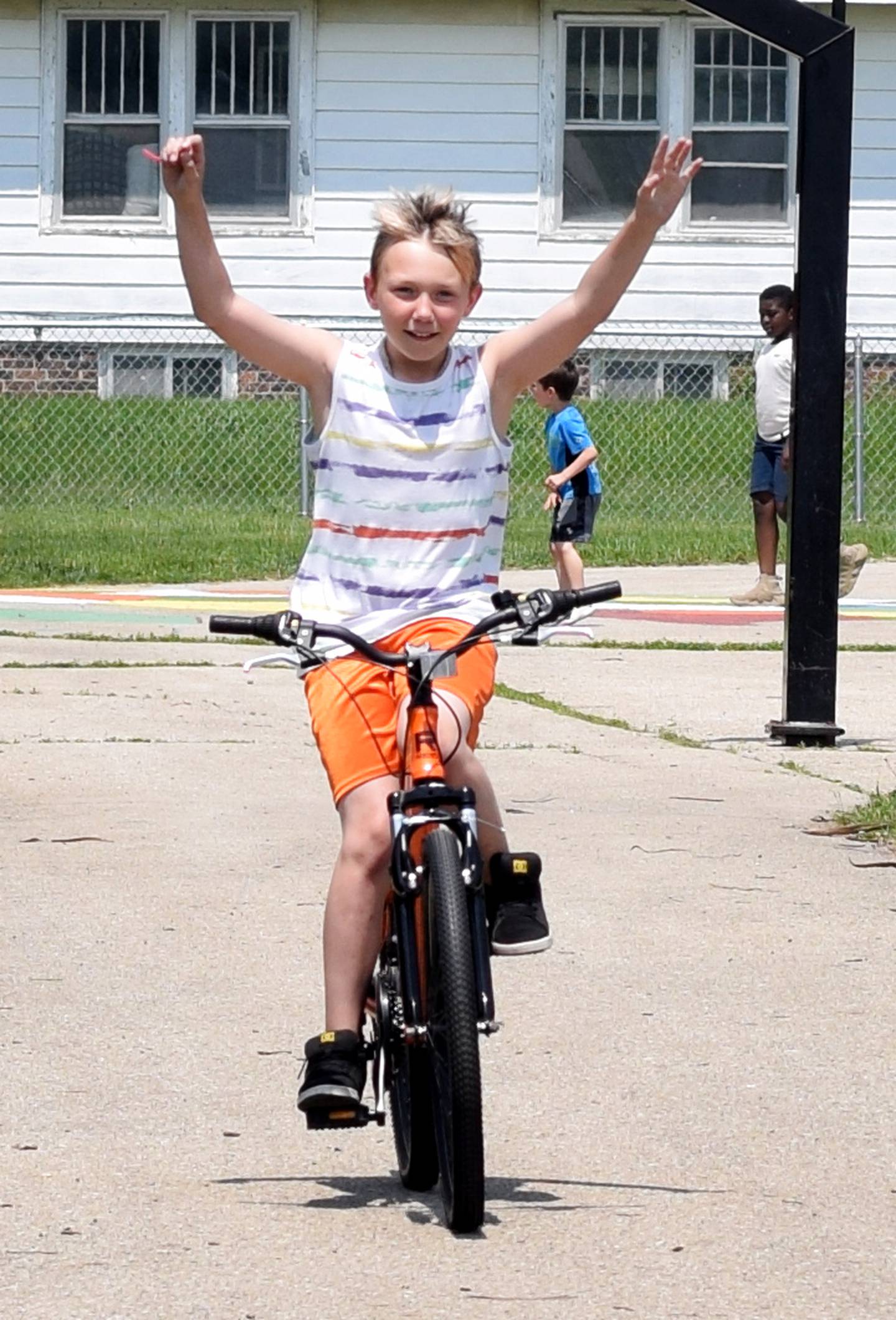 Erick Johnson-Carruthers, a third grade student at Emerson Hough Elementary School, shows off while riding his new bike he won from the Book for a Bike program, which is sponsored by the Newton Masonic Lodge.