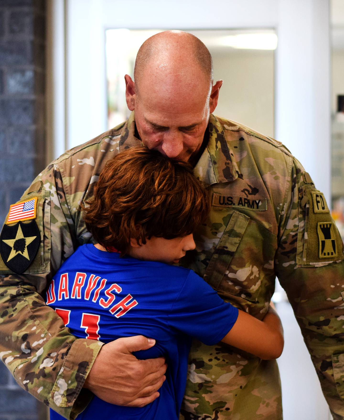 Cody Richards shares a moment with son Sam Richards after making a surpise return home from a deployment overseas. The sergeant first class disguised himself as Big Red and surprised the boys during Homecoming week.