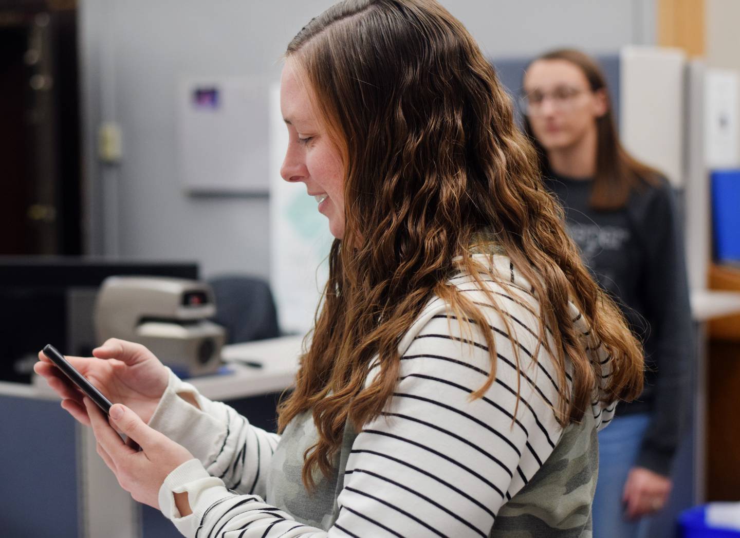 Jasper County Auditor Jenna Jennings tries to figure out a co-worker's cellphone while also trying to speak with a volunteer on the other line during Election Day.