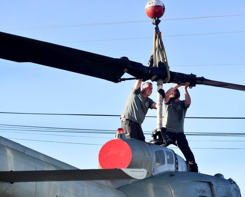 Crews from Midwest Aerospace and Dave's Crane & Wrecker Service help lift the main rotor blade to a Huey helicopter on Sept. 30 in Baxter.