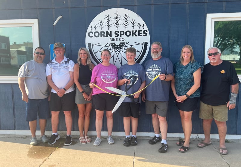 Members of the Monroe City Council stand with Corn Spokes Bike Co. owners Jenny, Elliot and Matt Van Gelder, center, during a ribbon cutting ceremony.