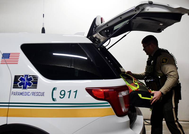 Steve Ashing, a reserve deputy paramedic for the Jasper County Sheriff's Office, loads a backpack full of medical supplies and equipment into the truck of his rescue vehicle. Ashing is part of the advanced life support pilot program at the sheriff's office, which allows part-time reserve deputies with paramedic-level training to respond to emergency calls in rural areas and assist volunteer agencies.