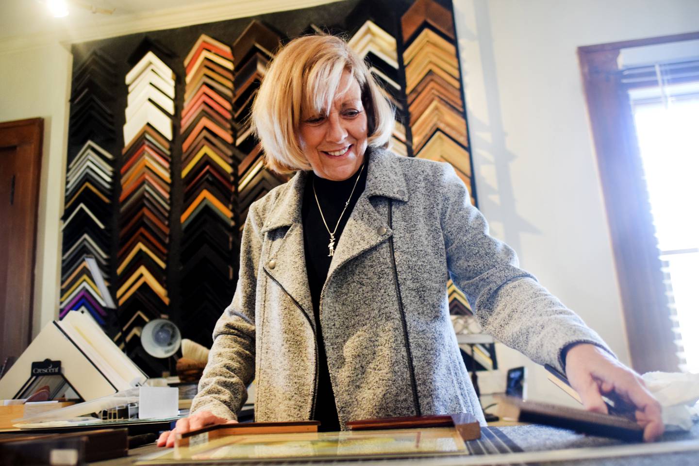 Pauli Zmolek Eades, owner of Cardinal Frame Shop, works on a frame The shop opened for business this past week to appointments, but it also welcomes walk-in traffic.
