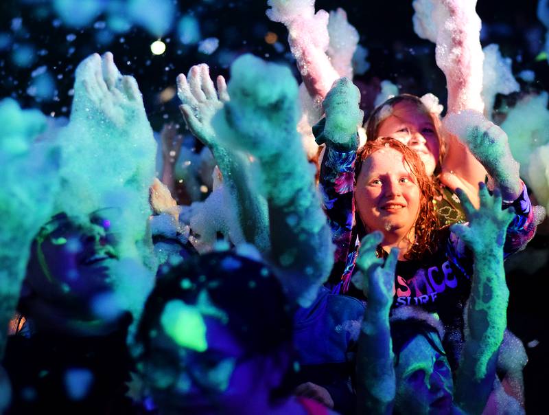 Kids participate in Driving Cap Entertainment's UV Glow Foam Party during Newton Fest on June 9 in Maytag Park in Newton.