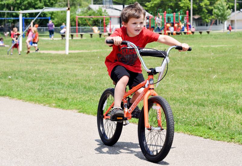 Abel Brown, a second grader at Emerson Hough Elementary School, tests out his new bike he won from the Book for a Bike program sponsored by Newton Masonic Lodge. The bikes were assembled and provided by Joe Urias, owner of Mojo Cycling.