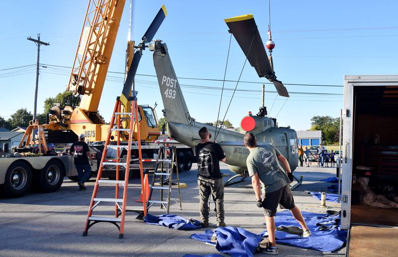 Crews from Midwest Aerospace and Dave's Crane & Wrecker Service help lift the main rotor blade to a Huey helicopter on Sept. 30 in Baxter.