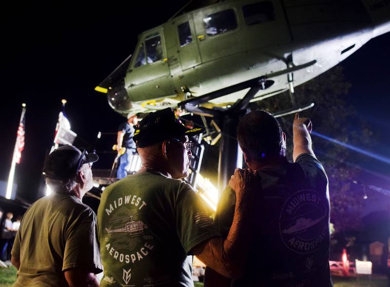Lynn Harnden, a retired Lt. Colonel of the U.S. Army, and Joe Giannini of Midwest Aerospace watch as the Huey helicopter monument is installed on raised platform on Sept. 30 in Baxter.
