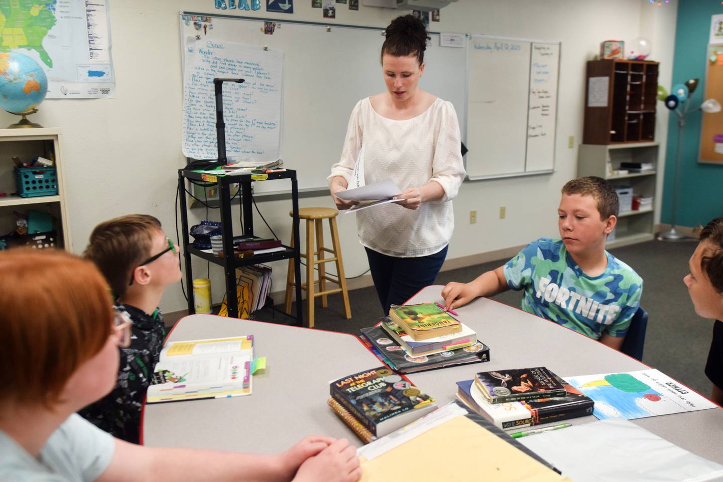 Teacher Jessica Moore of Newton Christian School passes out pages of a children's book that need colored. The book will eventually be put on display at the StoryWalk of Agnes Patterson Park.