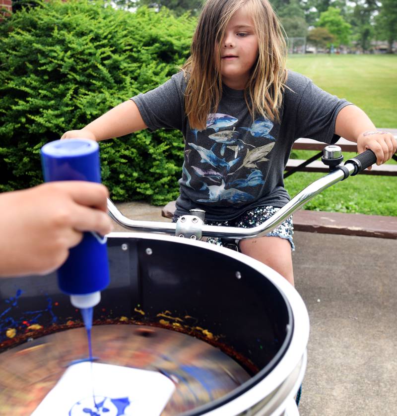 Iowa State University Extension and Outreach hold a spin art bike activity during Newton Fest on Saturday, June 10 at Maytag Park.