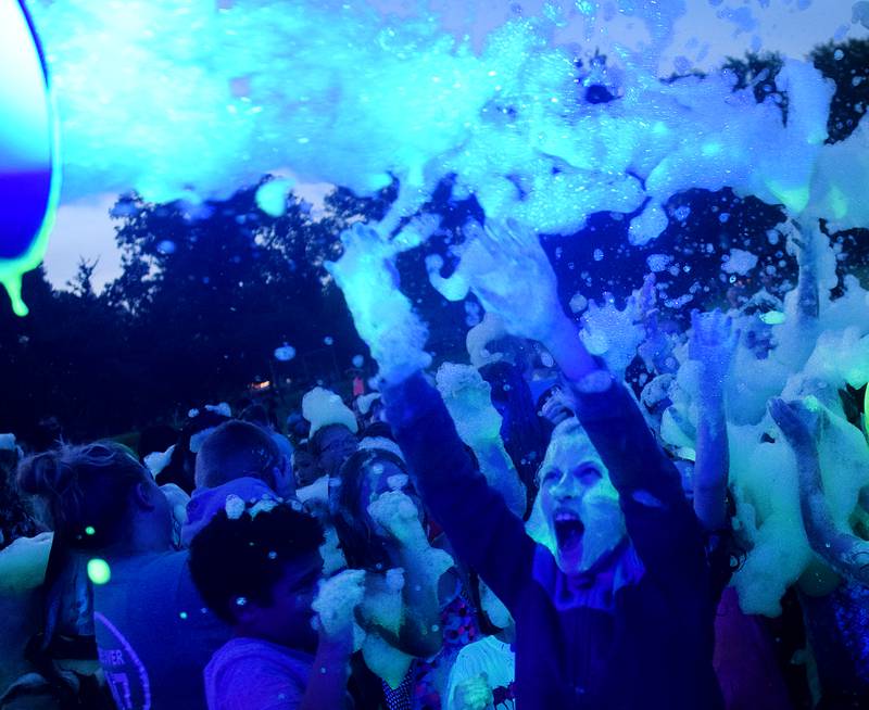 Kids participate in Driving Cap Entertainment's UV Glow Foam Party during Newton Fest on June 9 in Maytag Park in Newton.