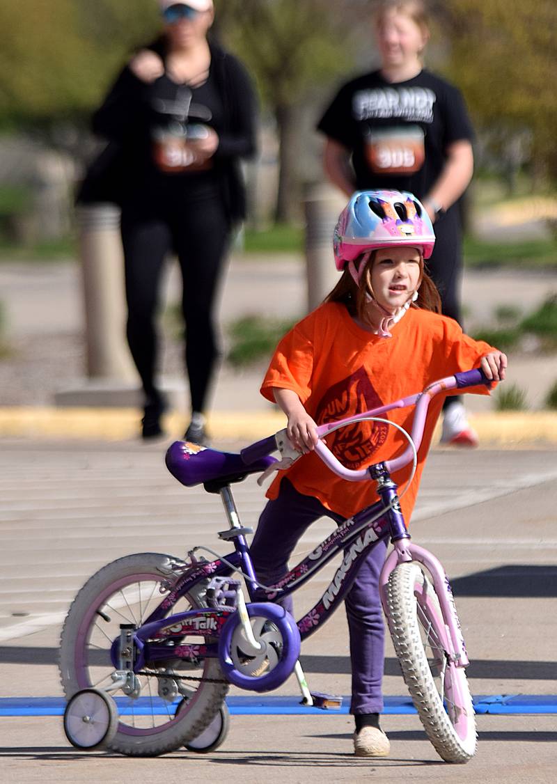 Runners, walkers and young bikers take off for the Run For Her Life 5K organized by nonprofit Phoenix Phase Initiative on April 29 at Legacy Plaza in Newton.