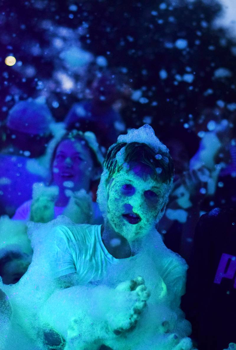 Kids participate in Driving Cap Entertainment's UV Glow Foam Party during Newton Fest on June 9 in Maytag Park in Newton.