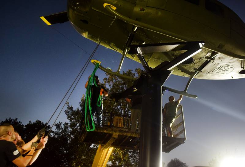 Crews attach anchors to the Huey helicopter monument on Sept. 30 in Baxter.