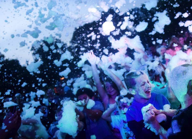Kids participate in Driving Cap Entertainment's UV Glow Foam Party during Newton Fest on June 9 in Maytag Park in Newton.