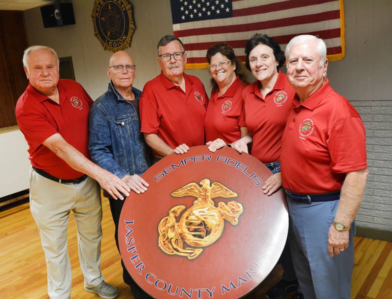 From left: Duane Wacha, Art Heikkila, Wesley Justus, Charlotte Ross, Mady McKim and Leo Yokiel showcase a table featuring the U.S. Marine Corps insignia at the American Legion Post 111 in Newton.