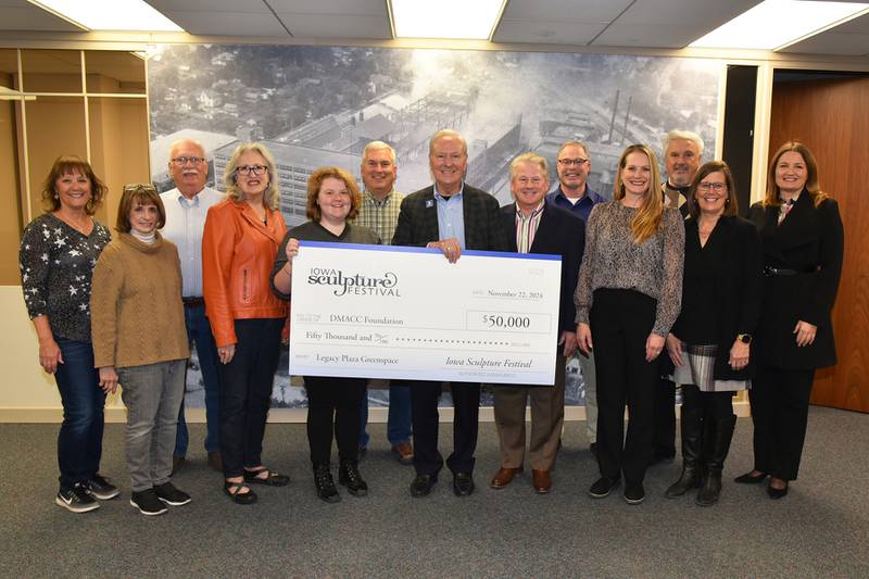 Representatives from the Iowa Sculpture Festival present a $50,000 check to the DMACC Foundation to be used for the DMACC Newton Campus Legacy Plaza Greenspace.  Those taking part in the check presentation include: from left, Kimbra Korte, ISF Committee member; Linda Klepinger, former director of the Center for Arts and Artists; Bruce Showalter, ISF Board member; Terri Ayres, executive secretary of CAA; Sophie Kruger, executive director of CAA; Jack Topp, CAA and ISF Board Chair; Rob Denson, DMACC President; Chris Vernon, Legacy Plaza Greenspace Committee Co-Chair; Bill Peters, DMACC Newton Campus Executive Dean; Denise Vernon, Legacy Plaza Greenspace Committee Co-Chair; Joe Pugel, chair of the DMACC Board of Trustees; Kim Didier, executive director of DMACC Business Resources and Tara Connolly, DMACC Foundation Executive Director.