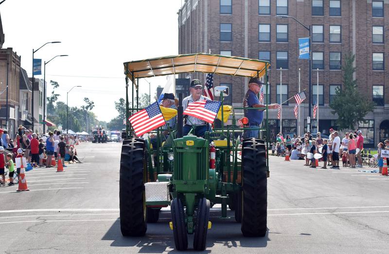 Bill Zegers drives a tractor carrying a tram of veterans through North Second Avenue during the Fourth of July Parade in Newton.