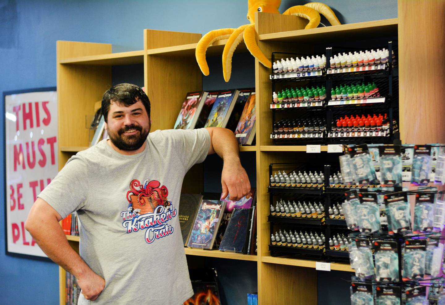Cody Soehnlen showcases the figurines and paint available at The Kraken's Crate, a new game store located at Legacy Plaza in Newton.