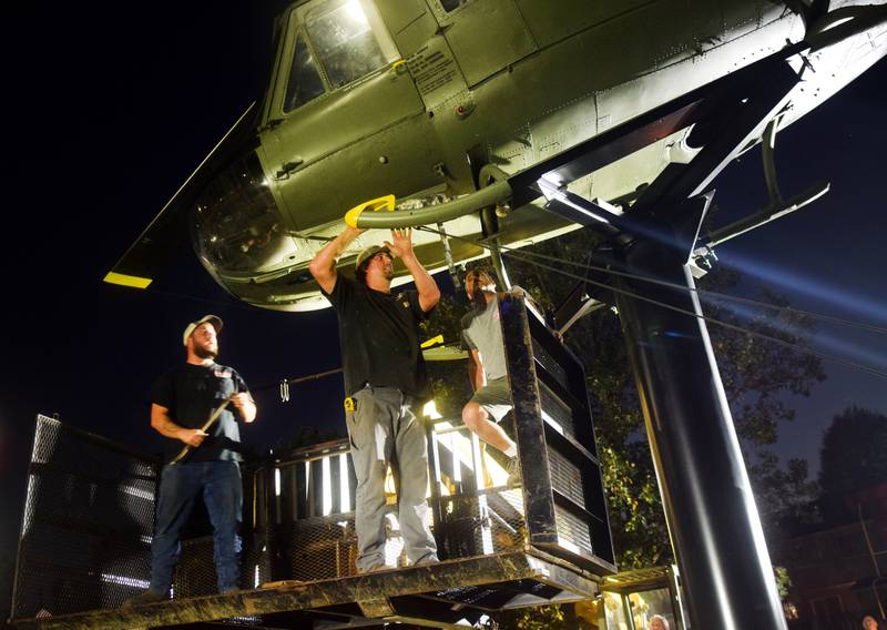 Crews attach anchors to the Huey helicopter monument on Sept. 30 in Baxter.