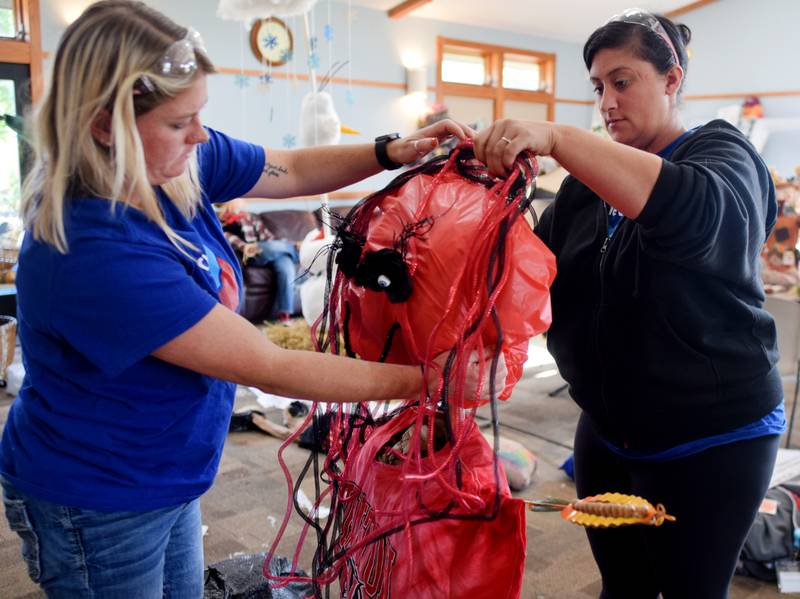 Sara Penning and Samantha Hayden of Chevron REG ready their scarecrow for the second annual Fall Fest and Scarecrow Walk held Oct. 12 at the Newton Arboretum and Botanical Gardens.