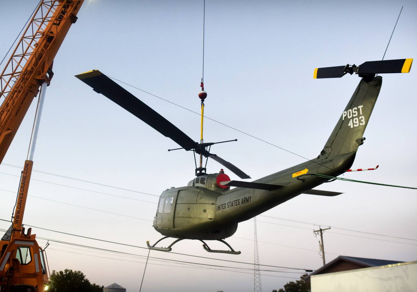 Dave's Crane & Wrecker Service help lift the Huey helicopter onto its raised platform on Sept. 30 in Baxter.
