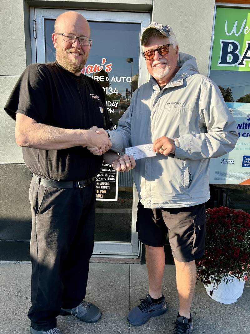 Ryan Dannan of Ryan's Tire and Auto, presents Steve Knight, representative of the Courthouse Lighting Fund, with a $500 donation to help make the downtown area bright during this year's holiday season.