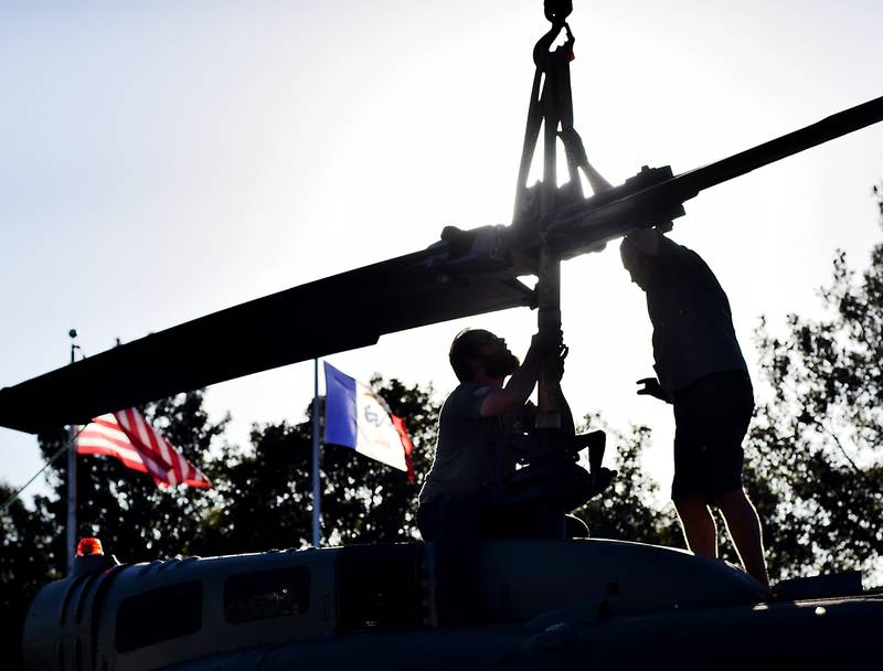 Crews from Midwest Aerospace and Dave's Crane & Wrecker Service help lift the main rotor blade to a Huey helicopter on Sept. 30 in Baxter.