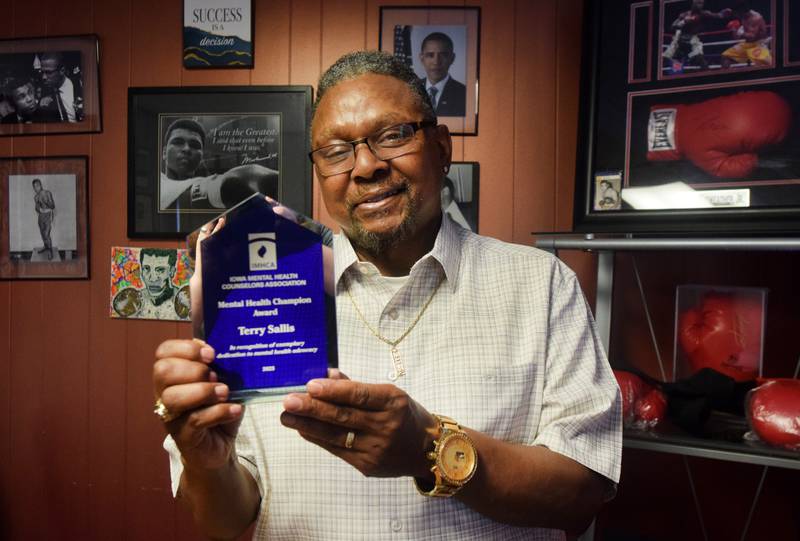 Terry Sallis, executive director of Integrated Treatment Services, shows off his Mental Health Champion Award given to him by the Iowa Mental Health Counselors Association.