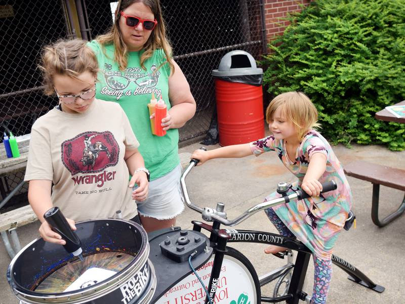 Iowa State University Extension and Outreach hold a spin art bike activity during Newton Fest on Saturday, June 10 at Maytag Park.