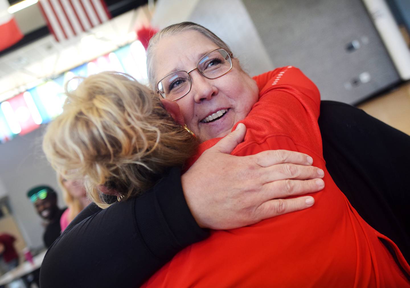 Jen Flake, a school nurse at Berg Middle School, embraces a fellow staff member after receiving the Above & Beyond Award from Newton Community Educational Foundation.