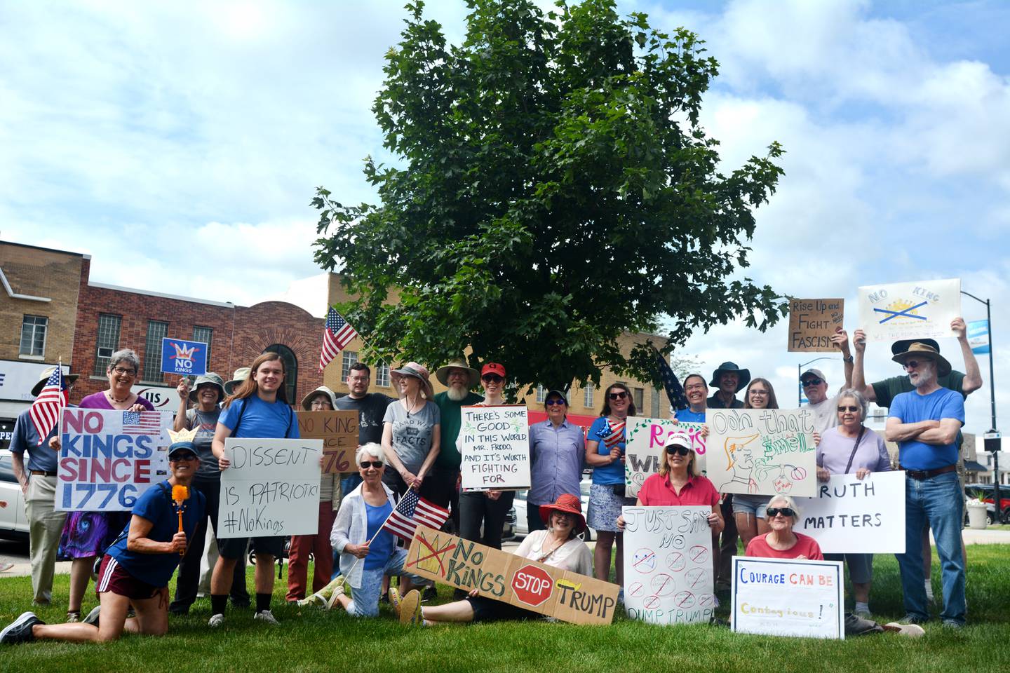 Protestors pose for a picture displaying anti-Trump signs during the "No Kings" protest June 14 at the Jasper County Courthouse in Newton.