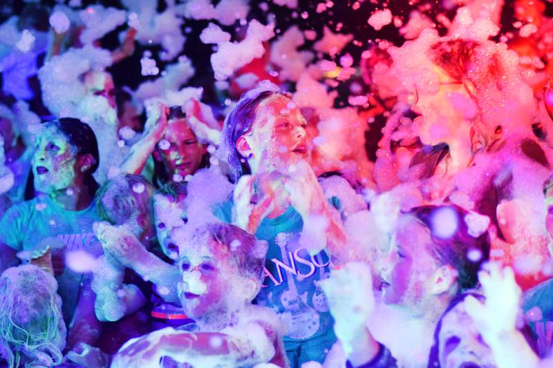Kids participate in Driving Cap Entertainment's UV Glow Foam Party during Newton Fest on June 9 in Maytag Park in Newton.