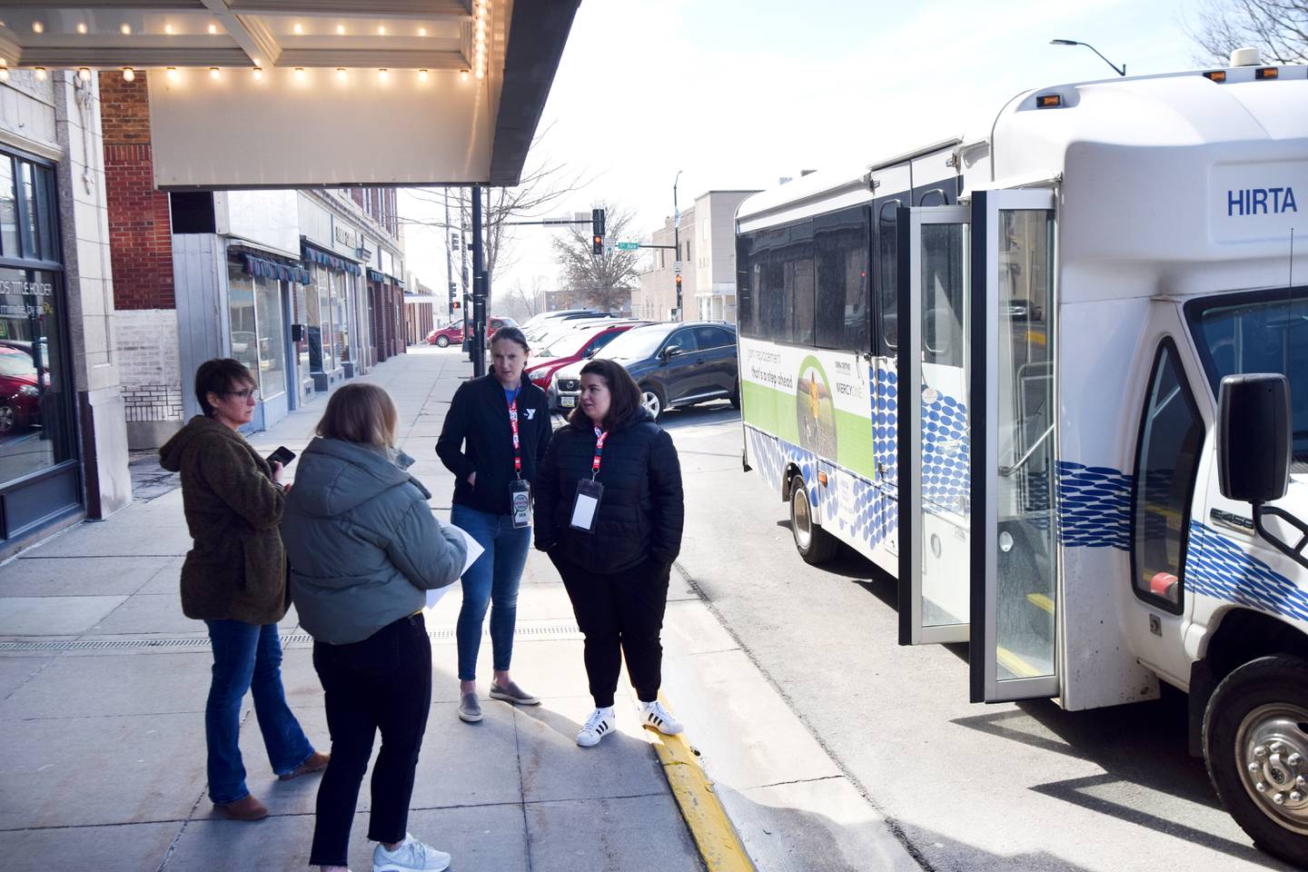 Crew members of Tour Newton gather outside the Capitol II Theatre on March 24 before hopping aboard the HIRTA bus. The tour lasted about one hour and showed visitors a number of different recreational areas, businesses and attractions in Newton.
