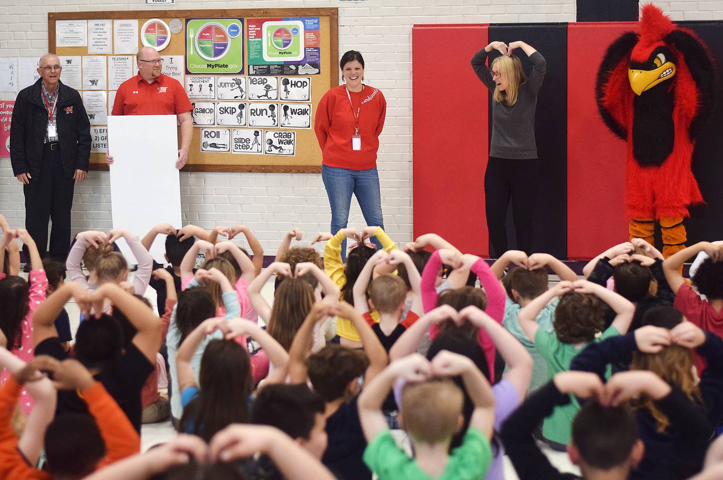 Tara Zehr, principal of Emerson Hough Elementary School, gets "big hearts" from her students after receiving the Above & Beyond Award from Newton Community Educational Foundation.