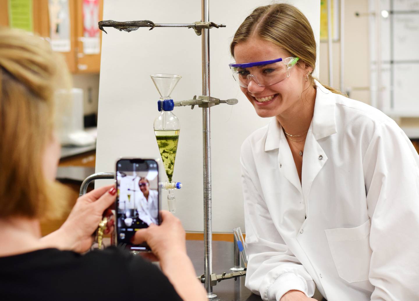 Senior Kallie Van Kley, 17, poses for a picture with biofuel made from algae on May 19 inside the Fledge classroom of Newton High School.