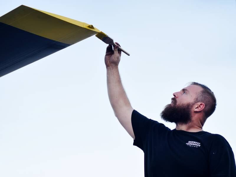 JT Mullins of Midwest Aerospace applies finishing touches to the rotor blade of a Huey helicopter on Sept. 30 in Baxter.