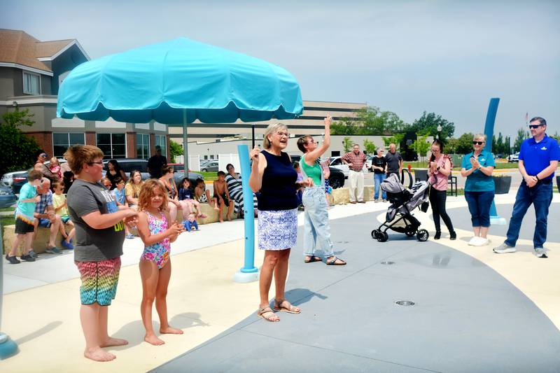 Newton Mayor Evelyn George speaks with families and children before they enjoy the new splash pad facilities. The Greater Newton Area Chamber of Commerce held a ribbon cutting ceremony for the splash pad June 6 in downtown Newton.