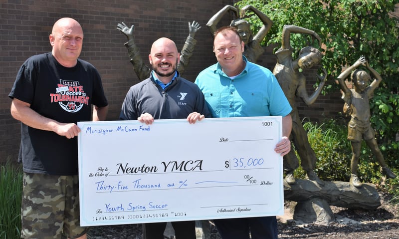 Scott Taylor, Lucas Hughes and Mark Thayer pose for a picture with the Monsignor McCann Community Fund grant awarded to the Newton YMCA for the spring soccer season and the middle school sports program.
