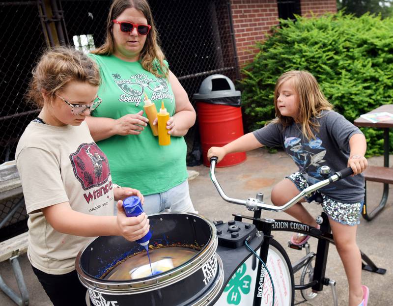 Iowa State University Extension and Outreach hold a spin art bike activity during Newton Fest on Saturday, June 10 at Maytag Park.