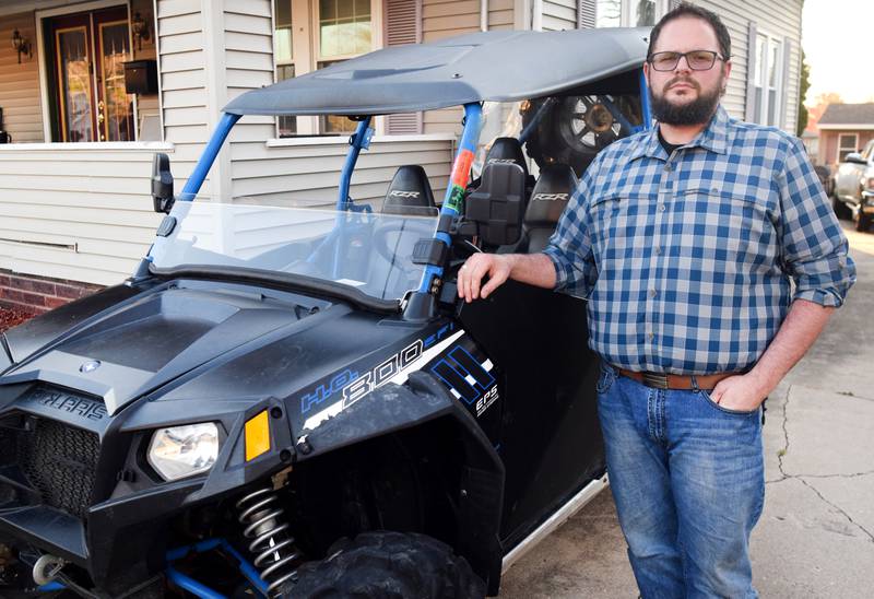 Brady Archibald, of Newton, stands next to his UTV outside his home. The city council passed the third reading of an ordinance allowing limited use of properly equipped ATVs and UTVs on city streets.