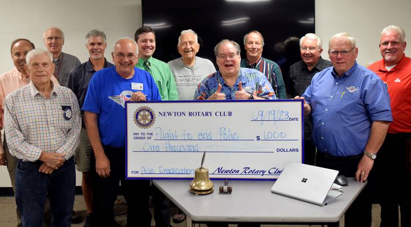 John Ockenfels, a member of the International Fellowship of Flying Rotarians and one of two pilots who flew around the world this summer in a single-engine airplane spreading awareness about polio eradication, accepts a check Sept. 19 from the Newton Rotary Club during its meeting at DMACC Newton Campus.