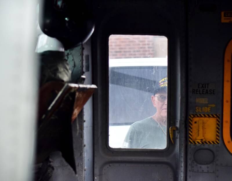 Lynn Harnden, a retired Lt. Colonel of the U.S. Army, takes one last look in the cockpit of the Huey helicopter that was hoisted onto a platform to serve as a memorial to Vietnam War veterans on Sept. 30 in Baxter.