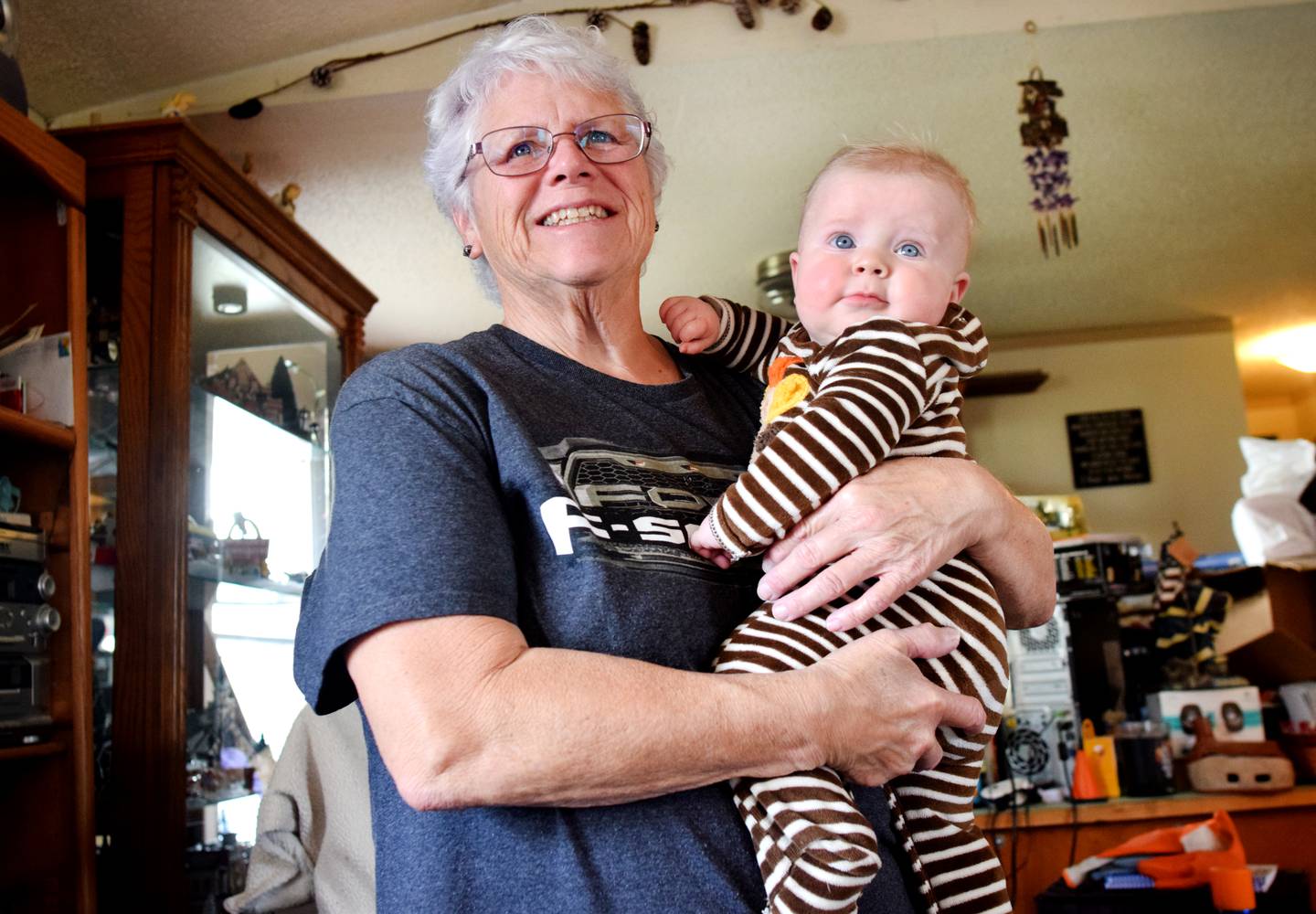 Pam Olson, a Democratic candidate running for a seat on the Jasper County Board of Supervisors, holds 6-month-old Mason while watching an episode of "Cocomelon" on Netflix inside her home on Nov. 8 in Newton.