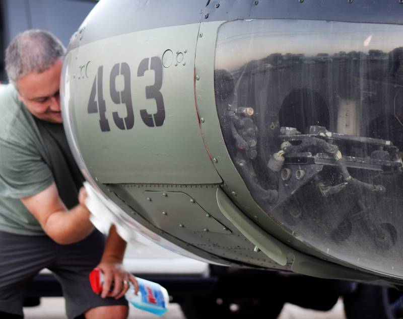 Joe Giannini of Midwest Aerospace wipes down a Huey helicopter on Sept. 30 in Baxter.