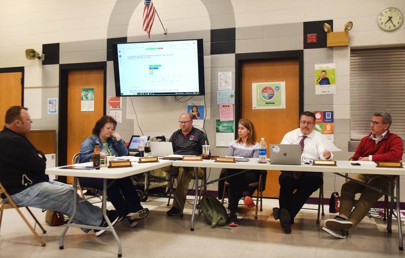 School board members and administrators of the Newton Community School District look over the results of a survey on March 20 in Emerson Hough Elementary School.